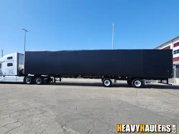 Transporting equipment in a conestoga trailer.